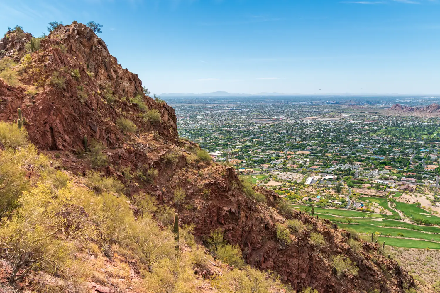 The Phoenix valley seen from Camelback Mountain, with saguaro and red rock in the foreground